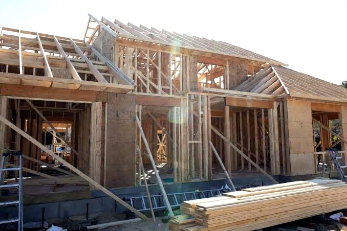 Custom home under construction with wall and roof framing in progress