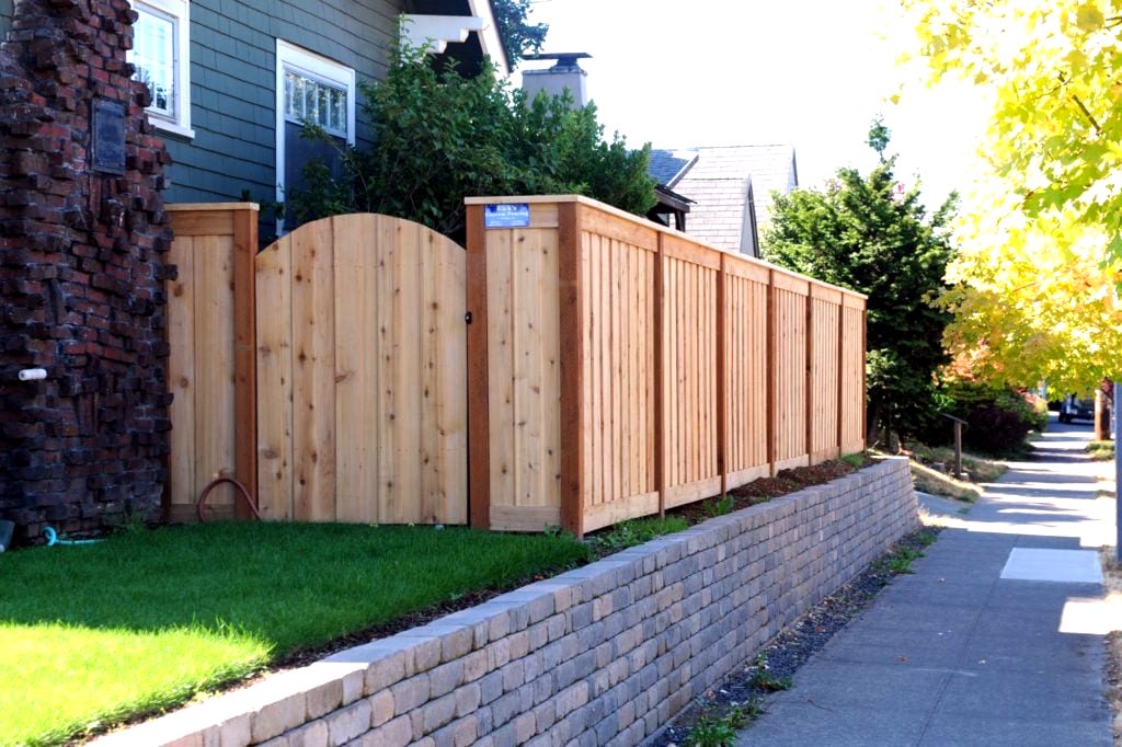 Cedar fence with an arched gate on a brick retaining wall