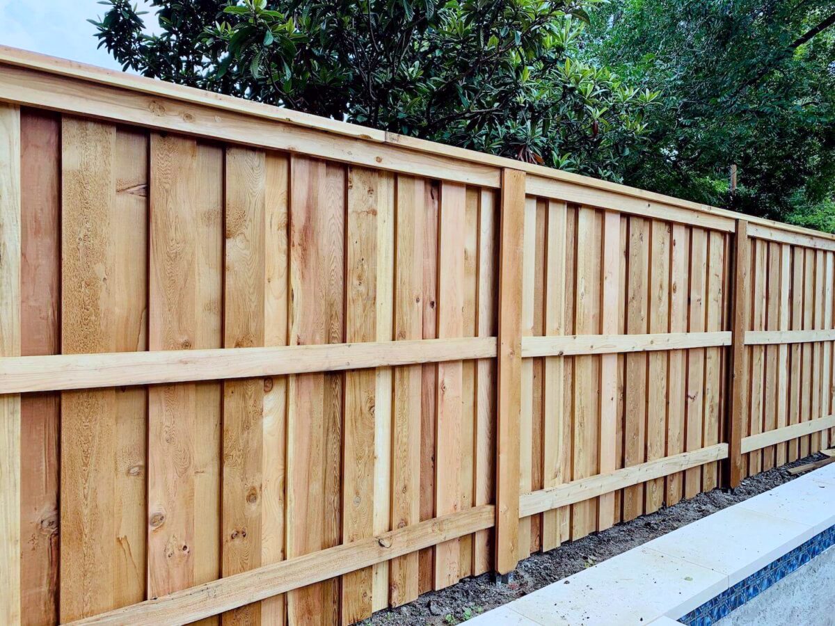 New cedar board-on-board privacy fence along a backyard